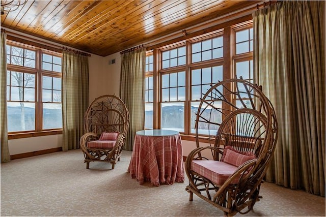 living area featuring carpet flooring, wood ceiling, and baseboards