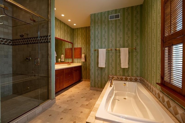 bathroom featuring wallpapered walls, a tub with jets, visible vents, and a stall shower