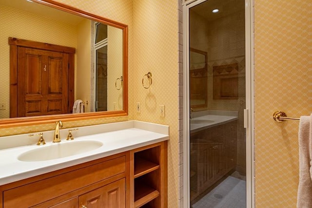 bathroom featuring vanity, a shower stall, and wallpapered walls