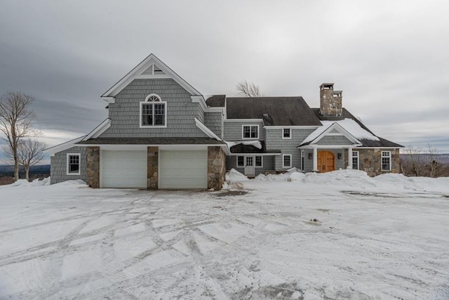 shingle-style home featuring stone siding and a chimney