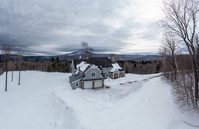 yard layered in snow featuring a mountain view