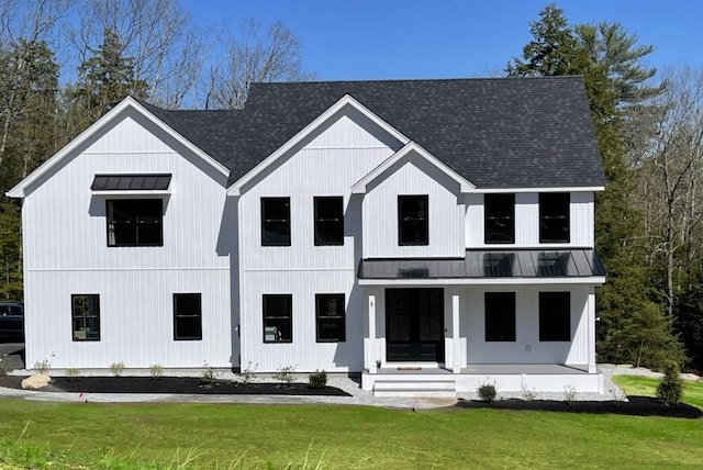 modern inspired farmhouse with a standing seam roof, a front yard, roof with shingles, and metal roof