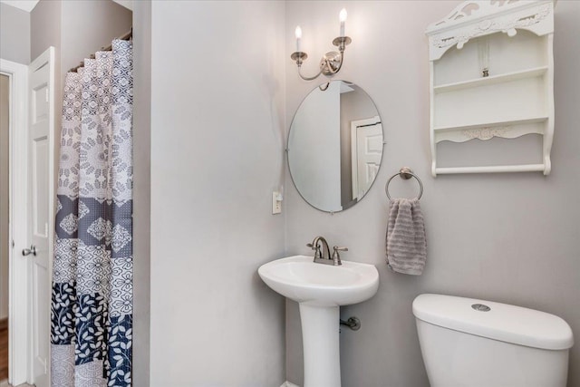 bathroom with a shower with curtain and toilet