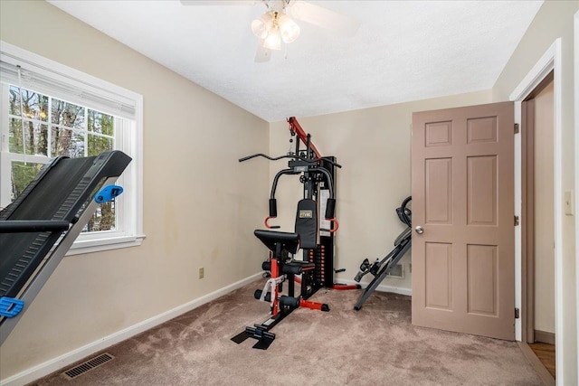 exercise room with visible vents, baseboards, carpet, and a ceiling fan