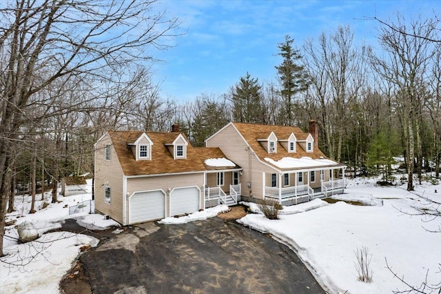 cape cod house with a chimney, a porch, and driveway