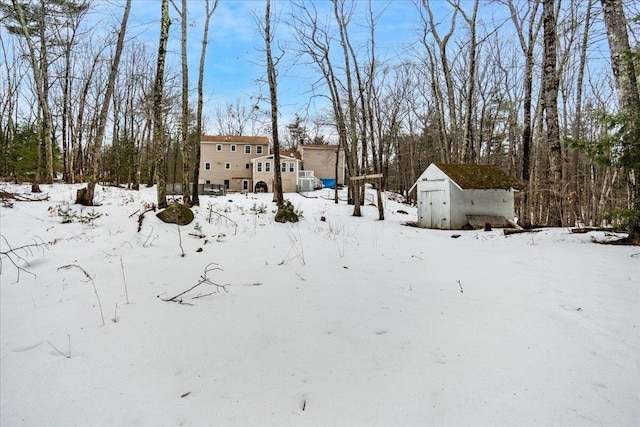 yard layered in snow with an outbuilding