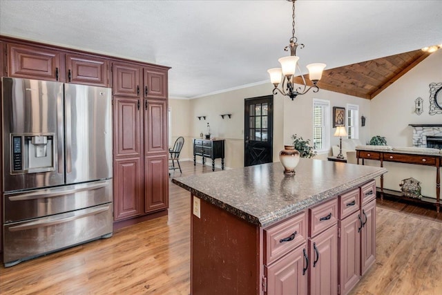 kitchen featuring vaulted ceiling, a kitchen island, light wood-type flooring, and stainless steel fridge with ice dispenser