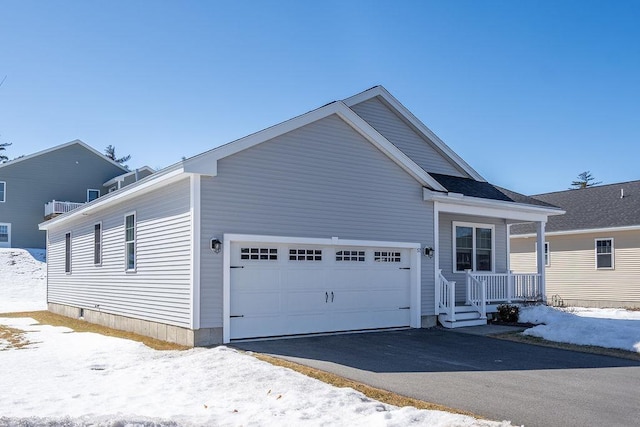 view of front facade featuring driveway, a porch, and an attached garage