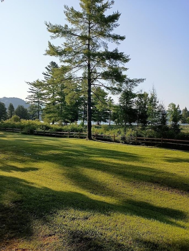 view of community with a yard and fence