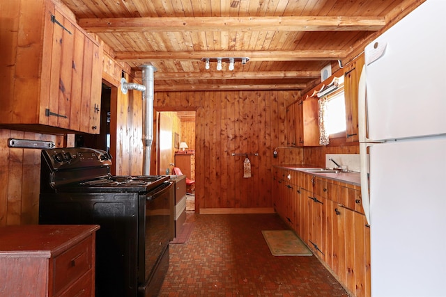 kitchen featuring beam ceiling, wooden walls, black electric range oven, and freestanding refrigerator