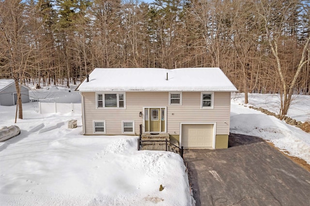 bi-level home with a garage and aphalt driveway