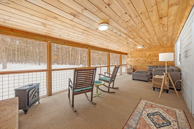 sunroom / solarium featuring wood ceiling, a wood stove, and vaulted ceiling