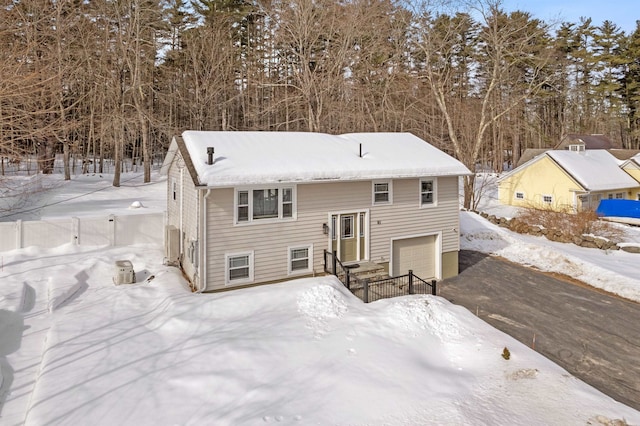 view of front of home featuring driveway, an attached garage, and fence