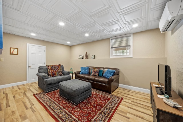 living room featuring recessed lighting, baseboards, an AC wall unit, and light wood finished floors