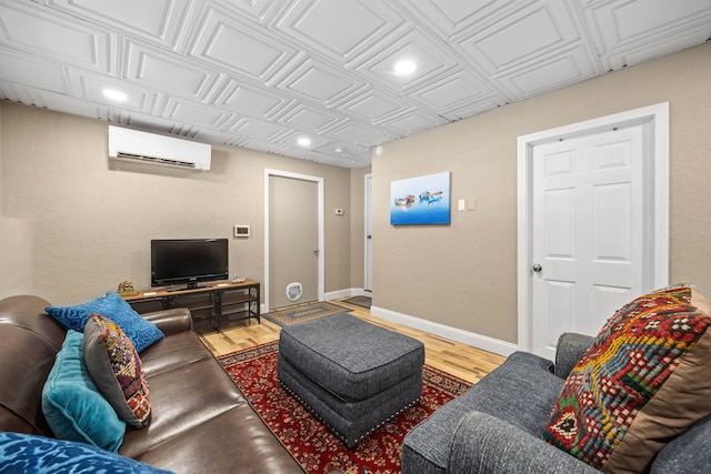 living room featuring baseboards, a wall unit AC, recessed lighting, wood finished floors, and an ornate ceiling