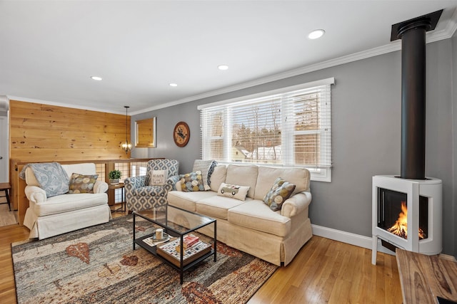 living room with a healthy amount of sunlight, a wood stove, and ornamental molding