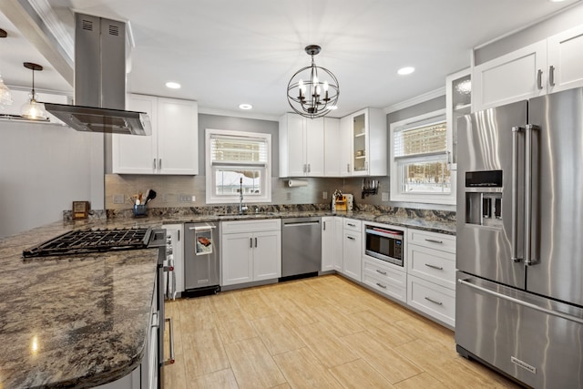 kitchen featuring island exhaust hood, high end appliances, white cabinets, and a healthy amount of sunlight