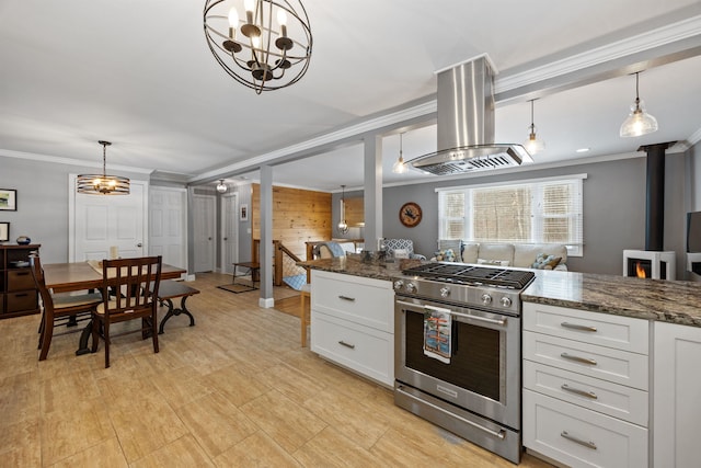 kitchen with island exhaust hood, white cabinets, high end range, and crown molding