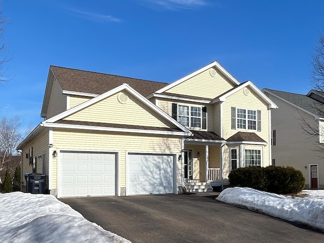 view of front of house with driveway, covered porch, and an attached garage