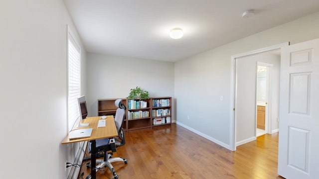 office area featuring baseboards and light wood-style flooring