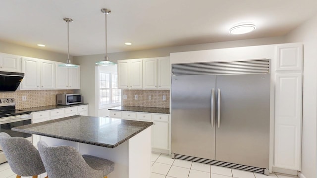 kitchen featuring decorative backsplash, appliances with stainless steel finishes, and white cabinets