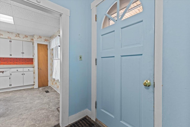 interior space with visible vents, baseboards, and a drop ceiling