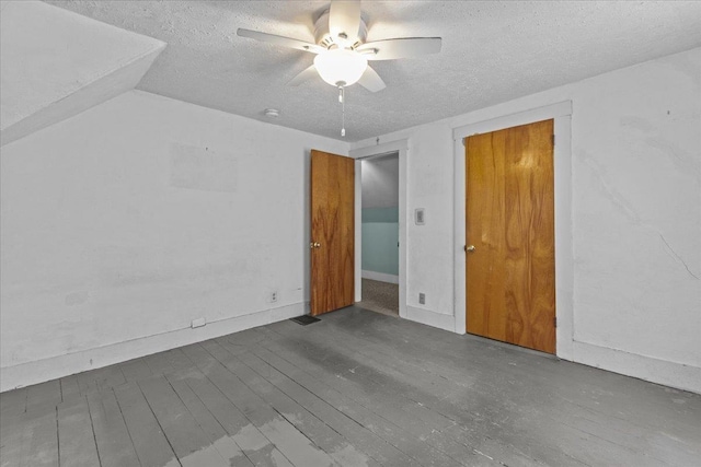 spare room featuring wood-type flooring, a textured ceiling, a ceiling fan, and vaulted ceiling