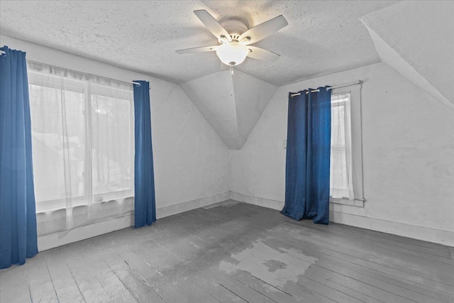 bonus room with vaulted ceiling, a textured ceiling, a ceiling fan, and hardwood / wood-style flooring