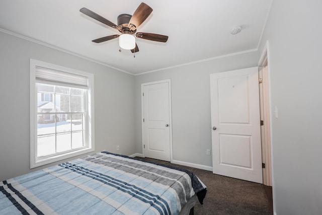 bedroom featuring dark carpet, a ceiling fan, crown molding, and baseboards