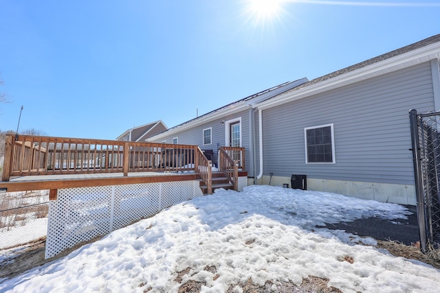 snow covered house with a wooden deck