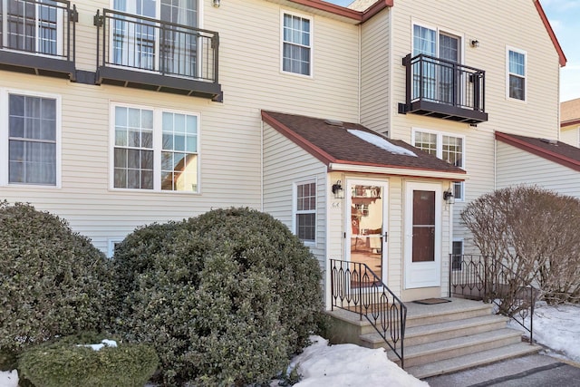 property entrance with a shingled roof