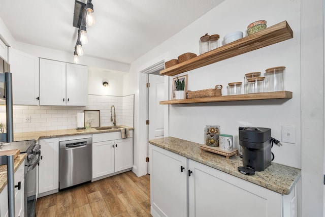 kitchen featuring open shelves, a sink, dishwasher, black electric range oven, and light wood-type flooring