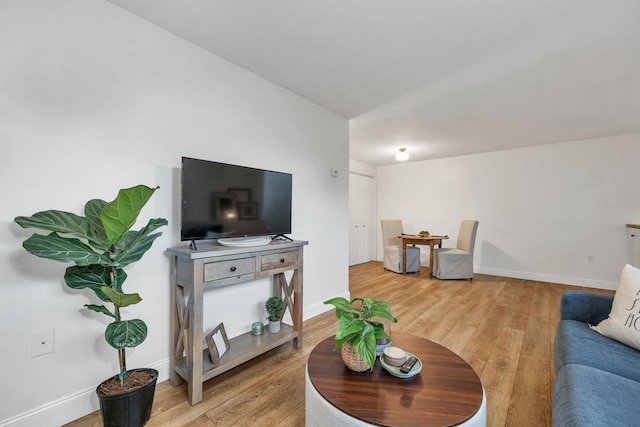 living room with baseboards and light wood-type flooring