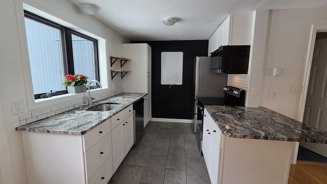 kitchen featuring a sink, open shelves, appliances with stainless steel finishes, white cabinets, and decorative backsplash