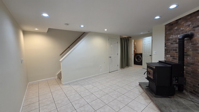 living room with washer / clothes dryer, recessed lighting, stairway, light tile patterned flooring, and a wood stove