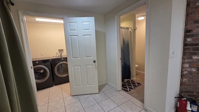 laundry area featuring light tile patterned floors, separate washer and dryer, and laundry area