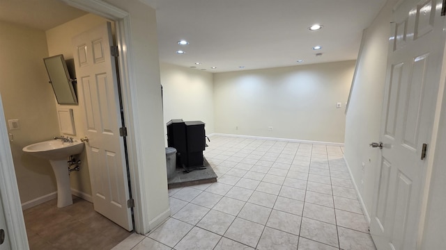 basement featuring recessed lighting, baseboards, and light tile patterned flooring