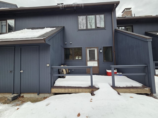 view of snow covered rear of property