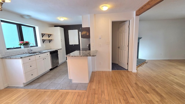 kitchen featuring a sink, backsplash, light wood-style floors, white cabinets, and dishwasher