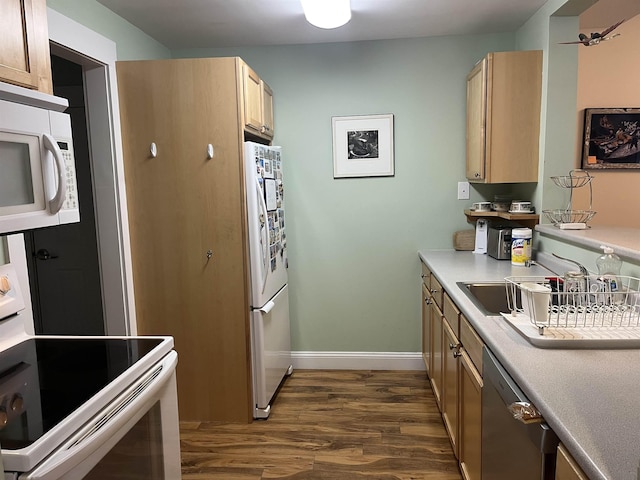 kitchen with light brown cabinets, a sink, dark wood finished floors, white appliances, and light countertops