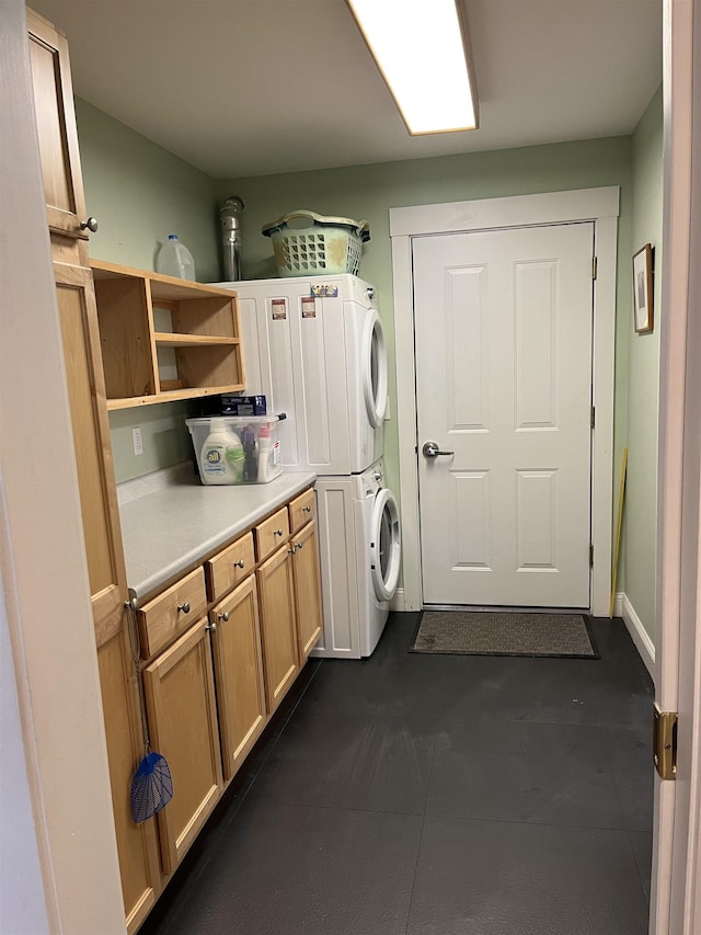 clothes washing area featuring cabinet space and stacked washer / drying machine