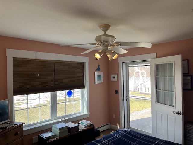 interior space with multiple windows, baseboard heating, a ceiling fan, and access to outside