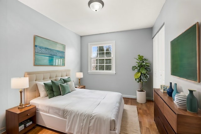 bedroom featuring wood finished floors, a closet, and baseboards