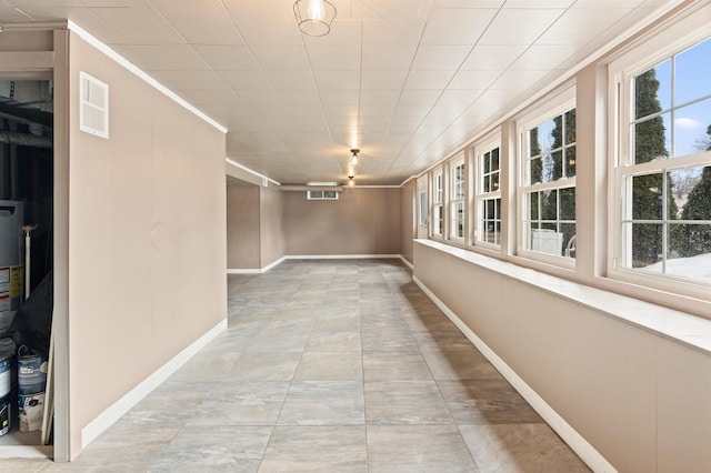 hall featuring a wealth of natural light, visible vents, and baseboards