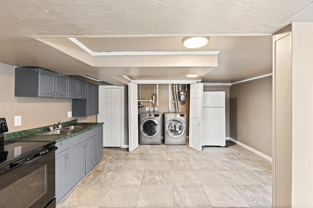 laundry room featuring a sink, baseboards, independent washer and dryer, and laundry area