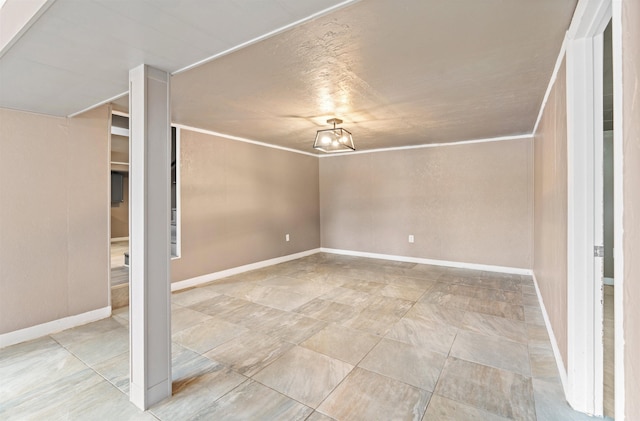 spare room with baseboards and crown molding