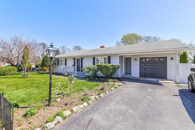 ranch-style house with a front lawn, fence, a garage, and driveway