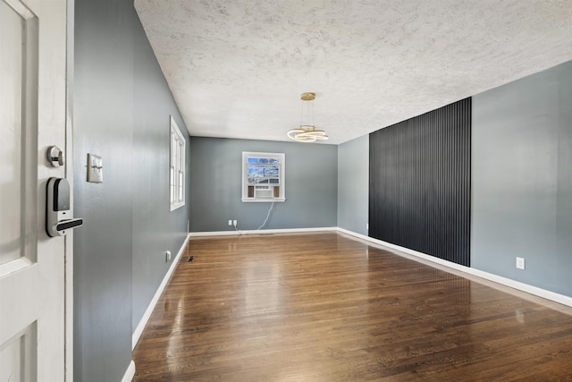 empty room with baseboards and wood finished floors