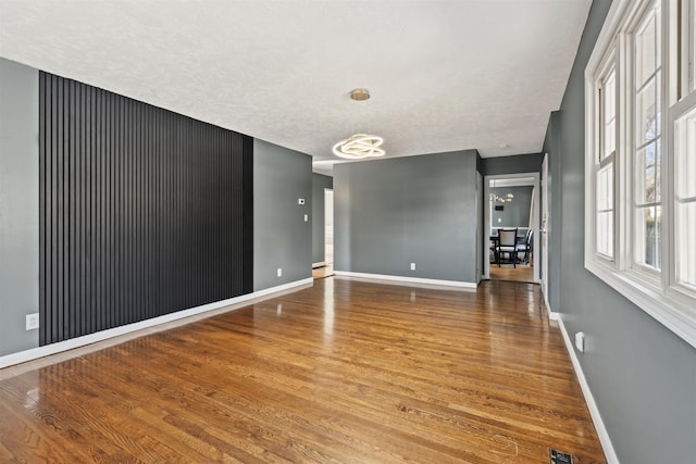 spare room with wood finished floors and baseboards