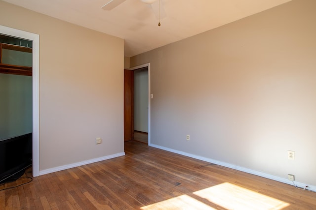 unfurnished bedroom with a closet, a ceiling fan, baseboards, and wood-type flooring